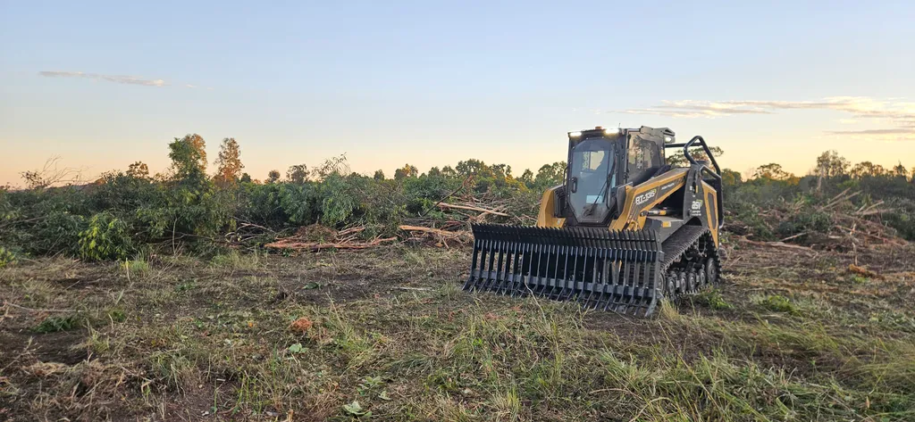ASV posi track with stick rake attachment at a large-scale clearing site